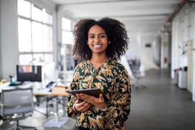 Confident businesswoman with digital tablet in office