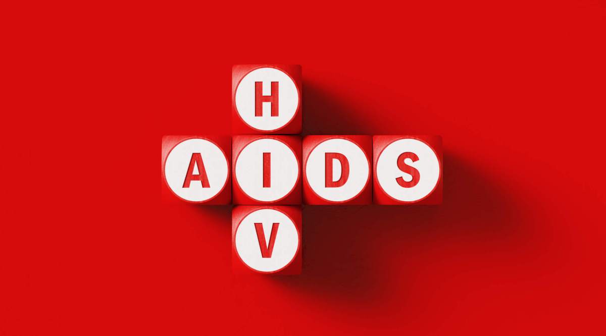 HIV and AIDS Written Woodblocks Sitting on Red Background