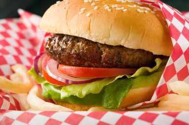 Hamburger with lettuce, tomato, red onion and French fries