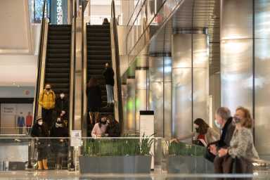 Shoppers wearing protective masks ride an escalator at Hudson Yards amid the coronavirus disease (COVID-19) pandemic in the Manhattan borough of New York City