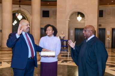 Manhattan DA Alvin Bragg takes the oath of office with his wife Jamila Marie Ponton holding the Bible and Clerk of New York County Milton Tingling administering