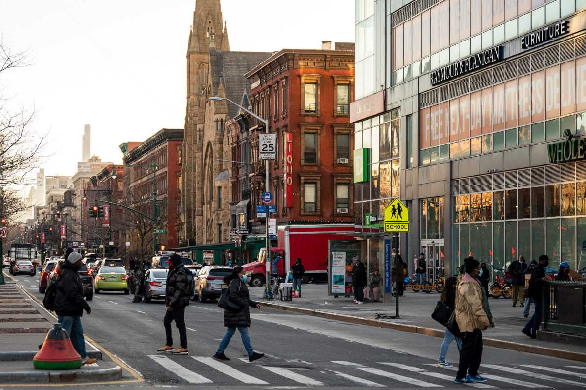 Pedestrians cross 125th Street in Harlem