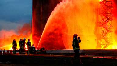 Rescuers work at a site of fuel storage facilities hit by cruise missiles in Lviv