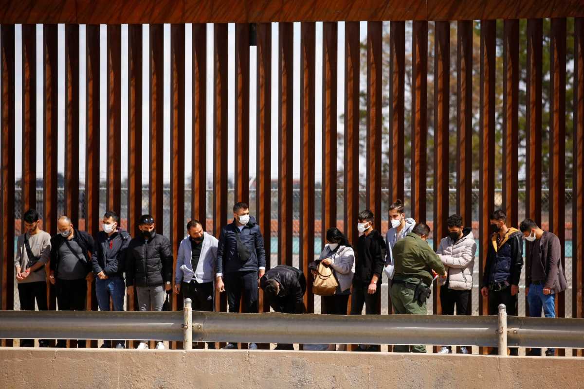 FILE PHOTO: Asylum-seeking migrants are detained by a U.S. Border Patrol agent after crossing the Rio Bravo river to turn themselves in to request asylum in El Paso, Texas, U.S., as seen from Ciudad Juarez