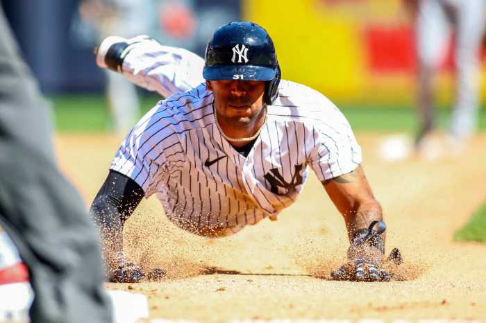 Yankees center fielder Aaron Hicks slides into third base.