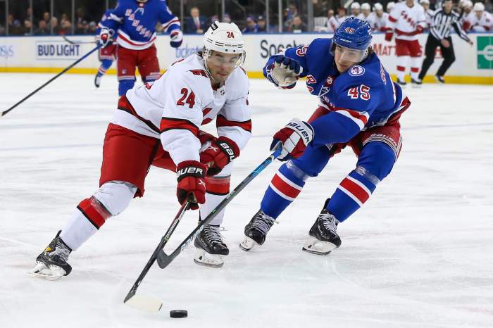 Carolina Hurricanes center Seth Jarvis moves the puck past New York Rangers defenseman Braden Schneider.