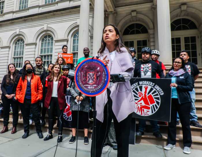 NYC Council expected to vote Monday on wage and workplace protections for delivery workers 6 woman standing at podium in front of group at city hall