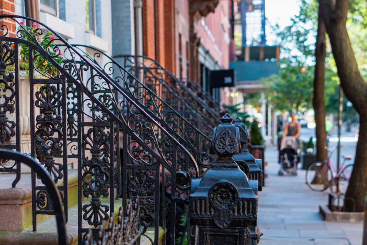 Classic red brick brownstone buildings with black iron railings in Greenwich Villages, Manhattan, New York Citty. Street scene