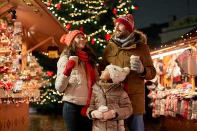 family with takeaway drinks at christmas market