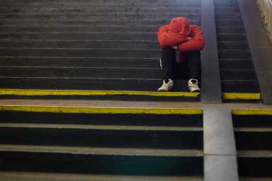 young homeless man sleeping on the street