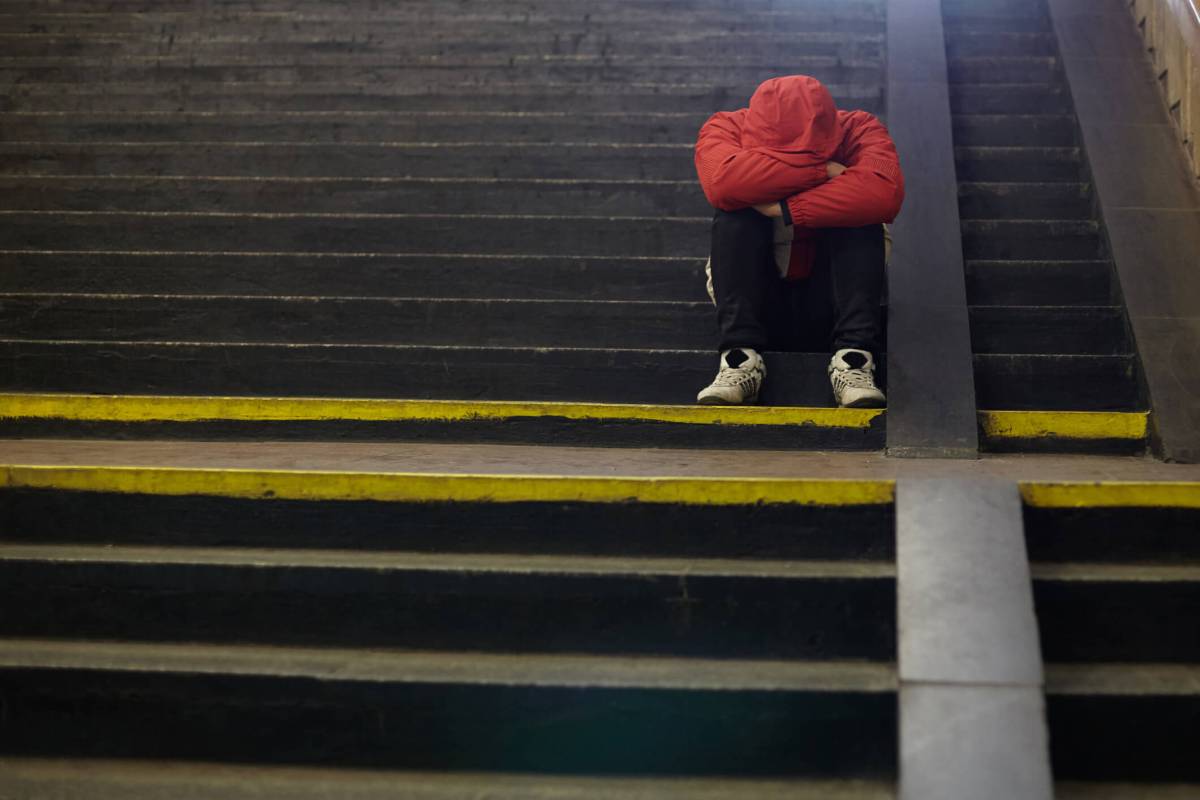 young homeless man sleeping on the street