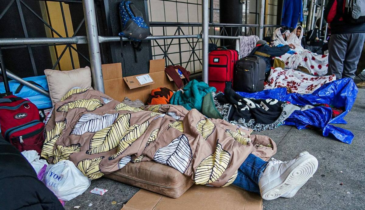Asylum seekers sleep outside of the Watson Hotel