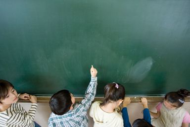 A boy writing on a blackboard