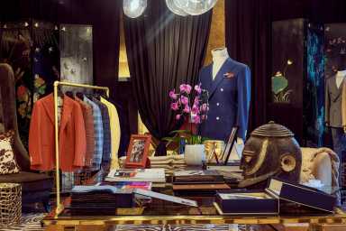 The interior of Sartoria Studio in Soho, featuring suits hanging up and custom decor.