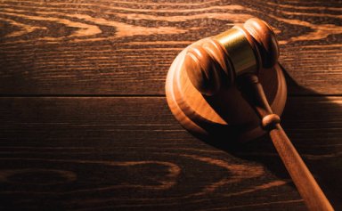 Wooden judge gavel hammer on wooden table background. Dramatic light. Copy space