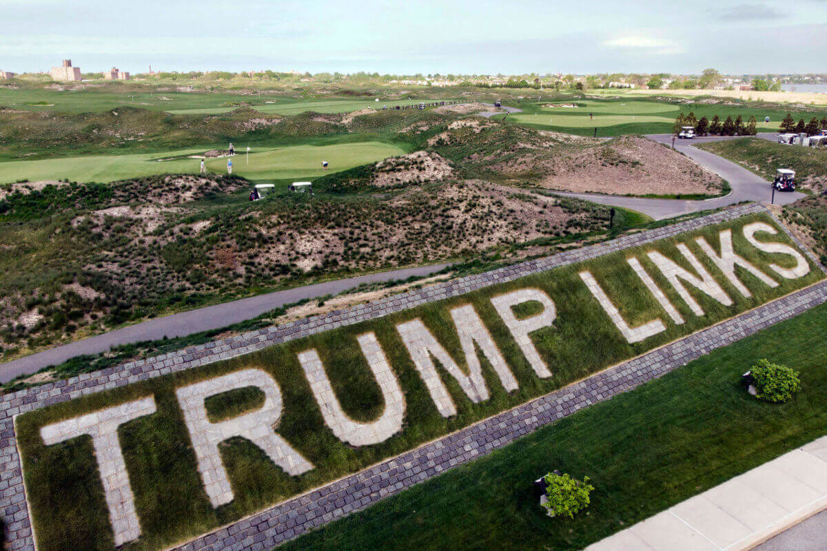 Patrons play the links as a giant branding sign is displayed with flagstones at Trump Golf Links, at Ferry Point