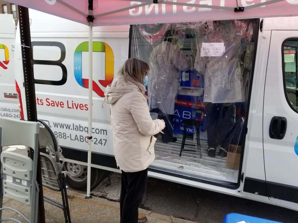 woman gets a COVID test at a LabQ van