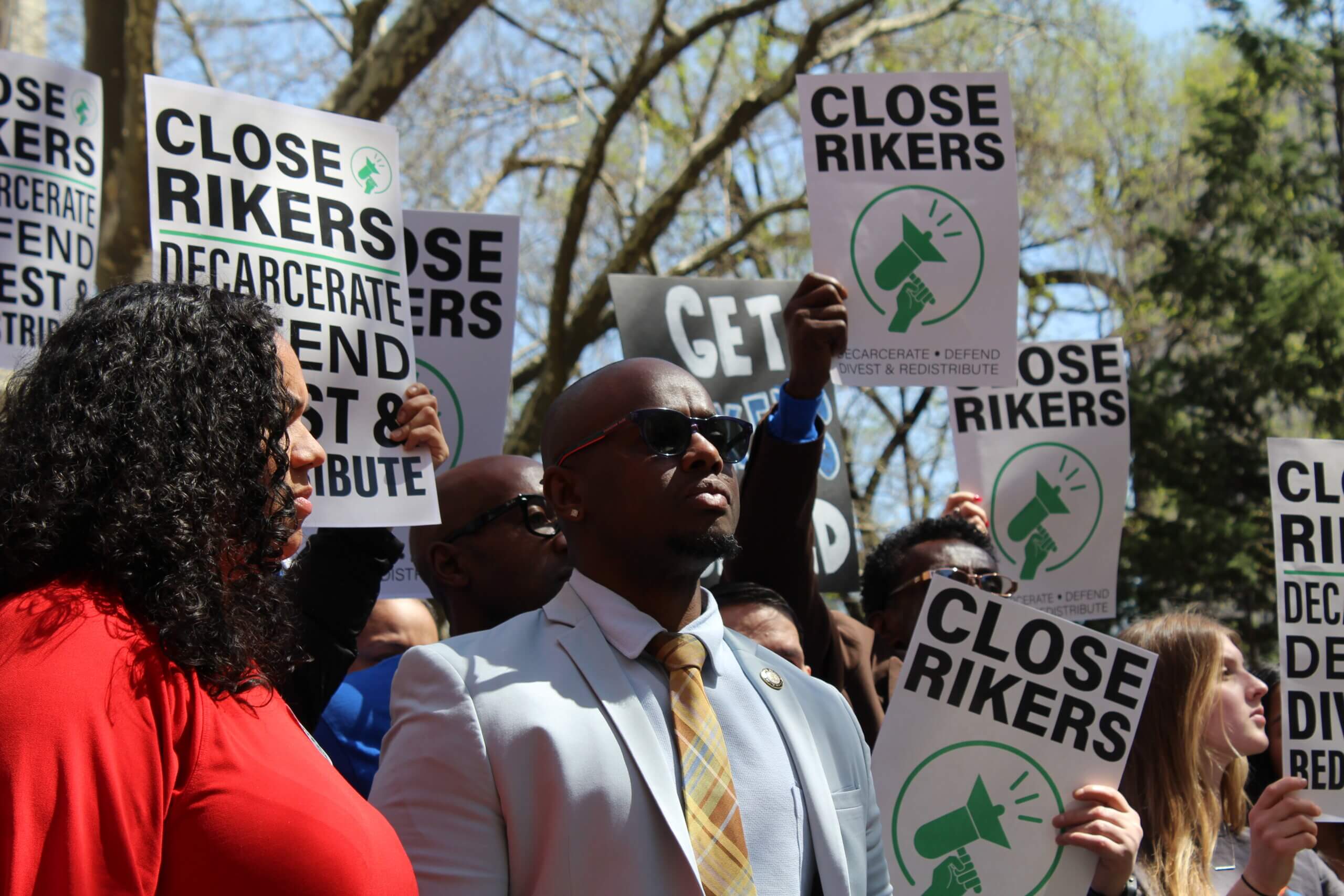 Council members intro plan to reduce Rikers population by nearly 3,000 3 Council Members Kevin Riley and Carmen De La Rosa at rally to close Rikers Island in City Hall Park