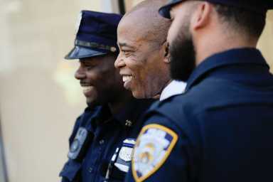 Mayor Eric Adams (center) standing with two police officers. Wednesday, May 17, 2023.
