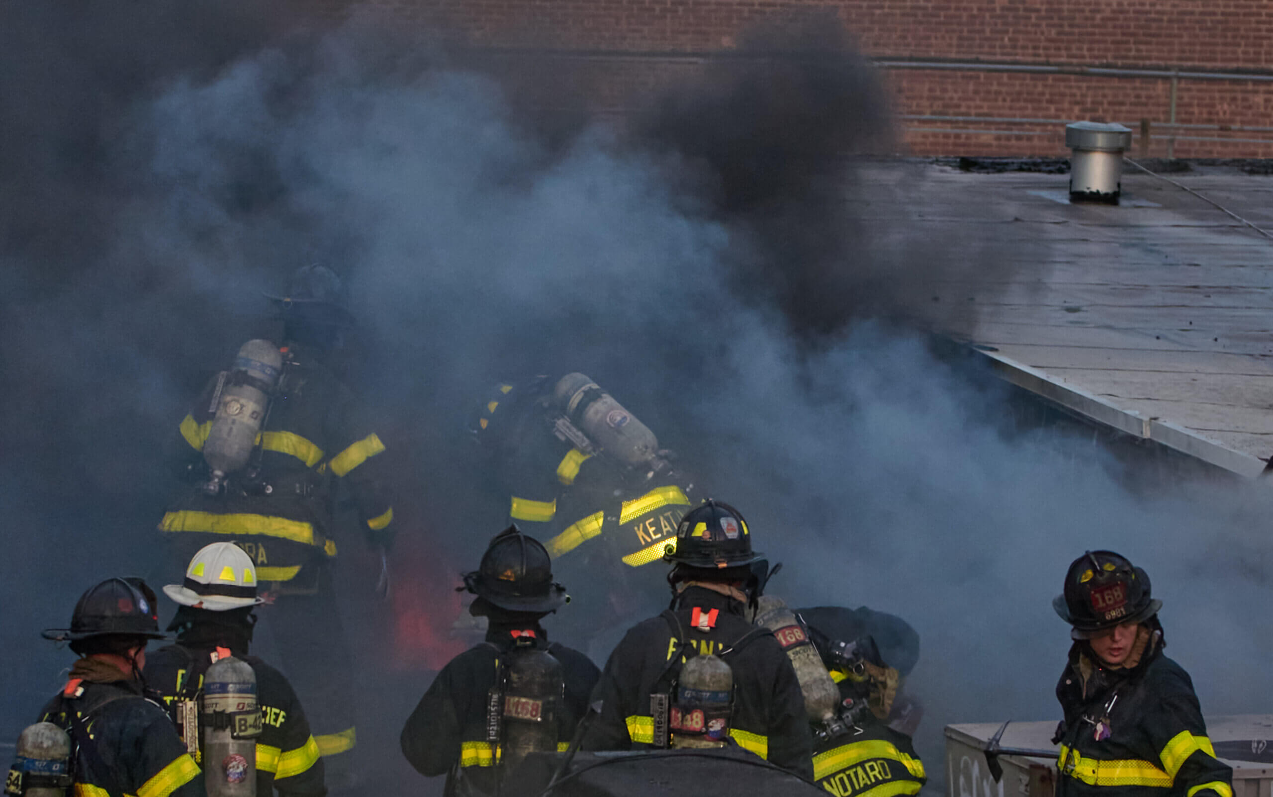 Firefighters work as heavy fire blows through the roof of a two story business on 5802 New Utrecht Avenue