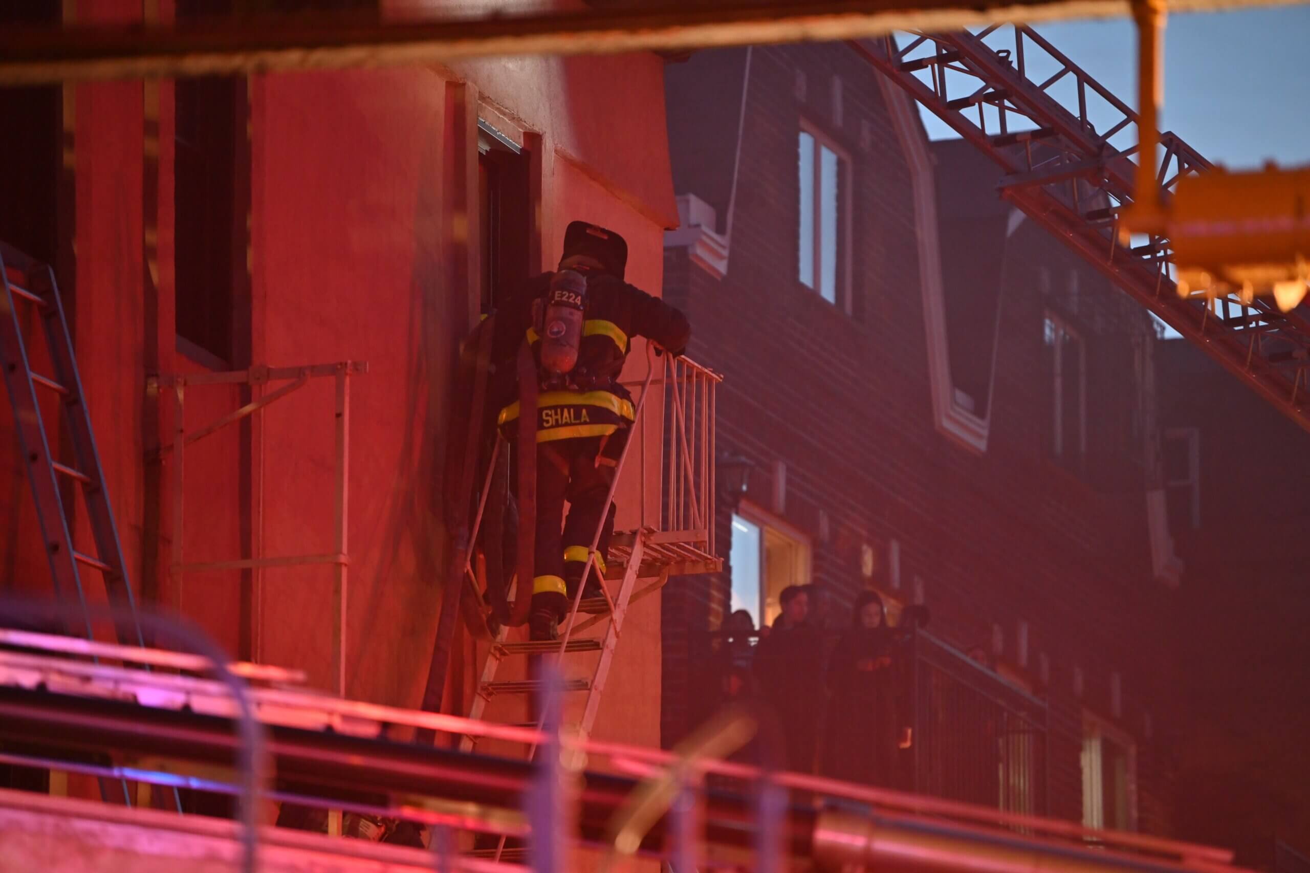 A firefighter works a hose-line during a four alarm