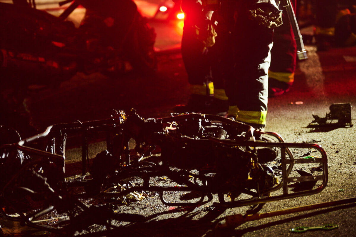 The frame of an electric bike lays on the sidewalk during a fire at 4201 Farragut Road