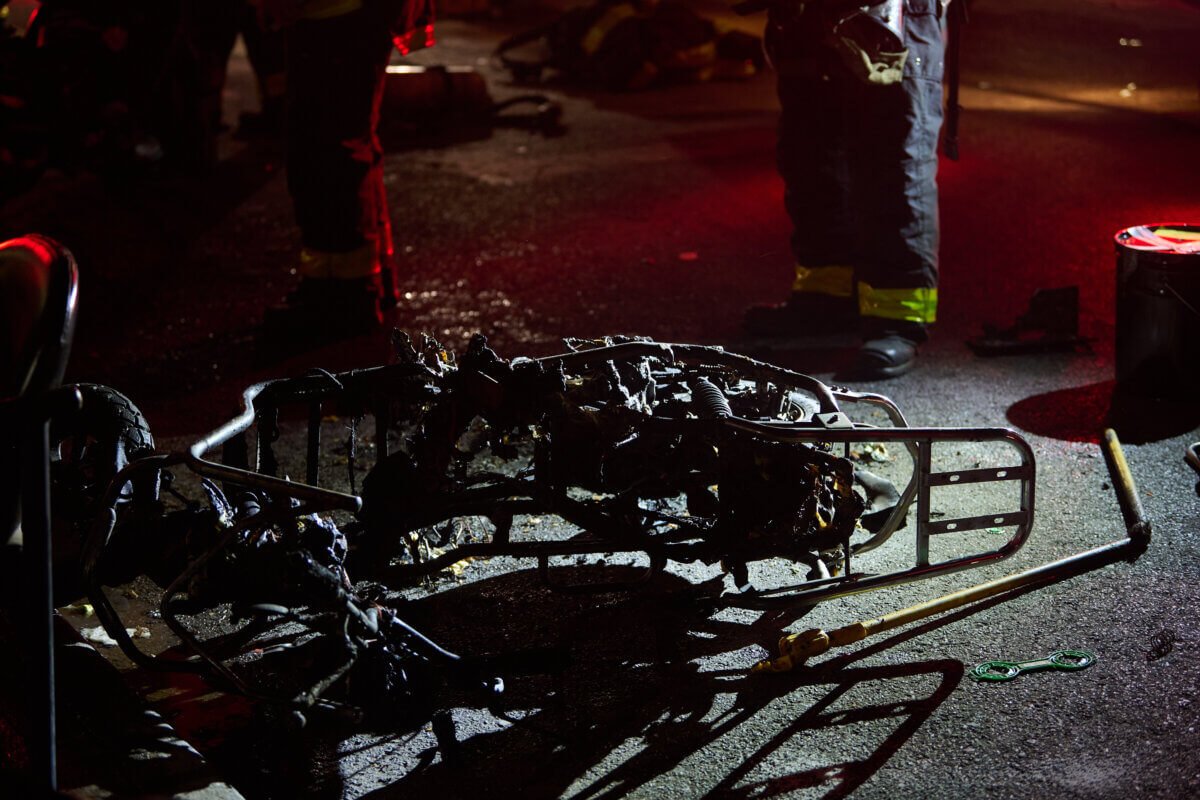 The frame of an electric bike lays on the sidewalk during a fire at 4201 Farragut Road