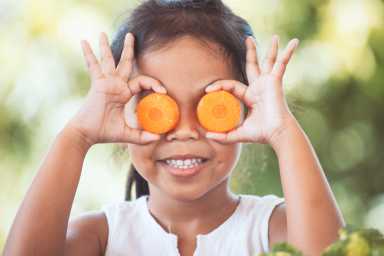Cute asian child girl having fun to learn about vegetables
