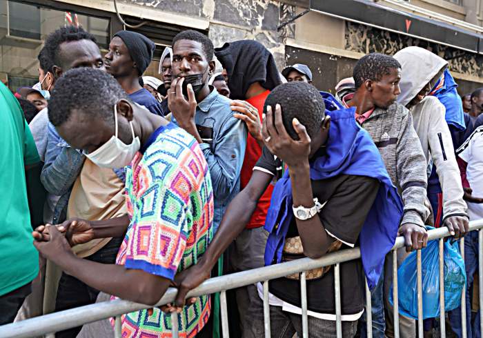 Hochul criticized Adams for the handling of Migrants, pictured here waiting online outside the Roosevelt Hotel.