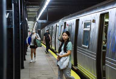 passengers exit Q train at 7th Ave