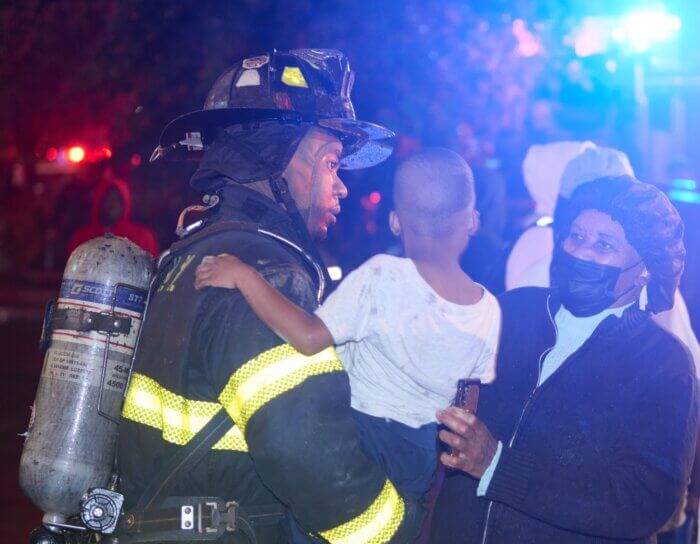 A firefighter helps a young boy at the scene of the blaze
