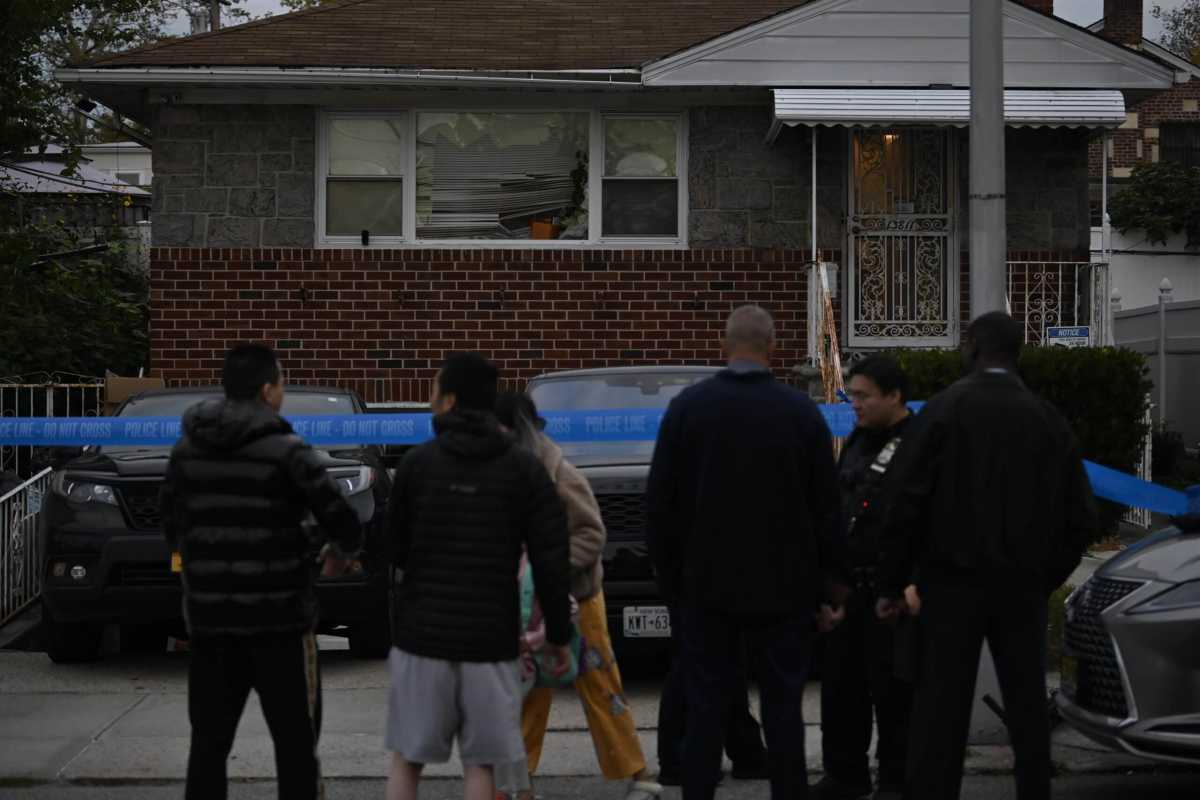 Police stand outside the Flushing, Queens home where a man was shot and critically injured during an apparent robbery on Oct. 18, 2023.