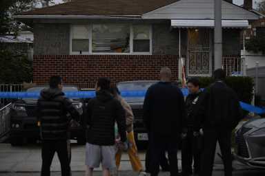 Police stand outside the Flushing, Queens home where a man was shot and critically injured during an apparent robbery on Oct. 18, 2023.