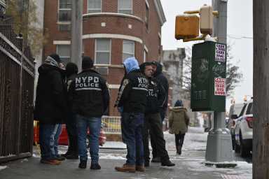 Police huddle after Brooklyn shooting