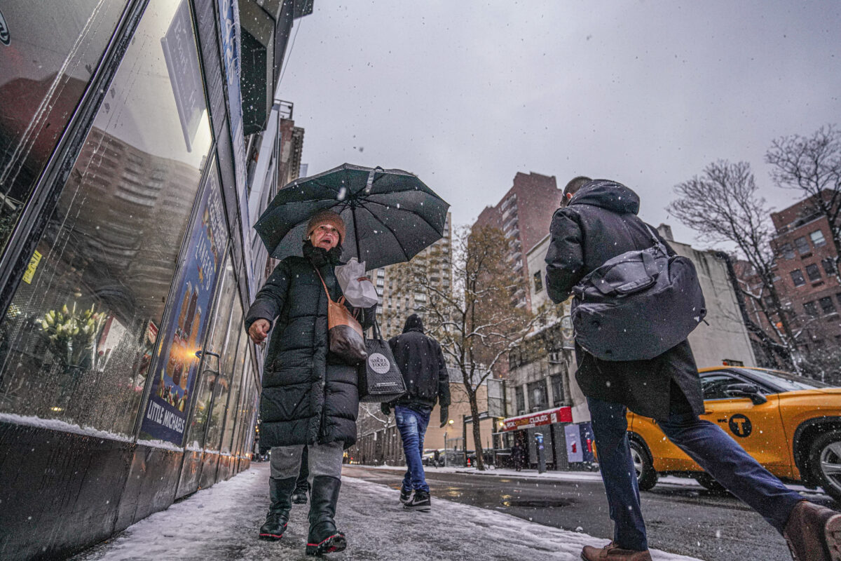 New Yorkers walk on snowy sidewalks