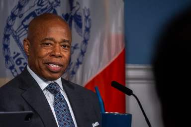 mayor of NYC, who has initiatives to help reduce Black unemployment, wearing a suit at a podium