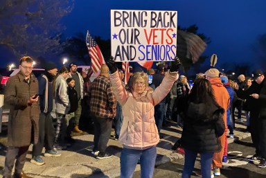 Staten Island resident holds up sign at protest over migrant shelter