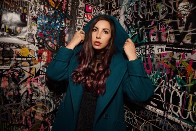 Publicity photo of Caitlin Cook in front of graffiti for The Writing on the Stall