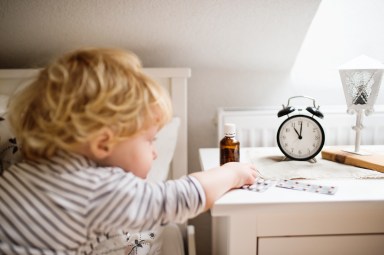 Child reaching for medication in poison danger