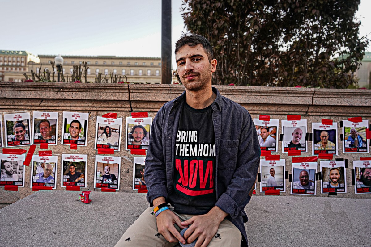 Columbia University student sits before hostage posters