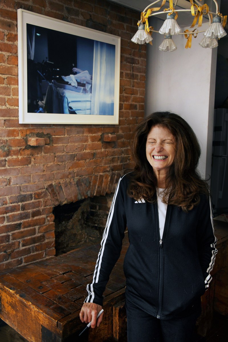 Barbara Nitke having a moment in the kitchen at the Storage APT gallery, with her work in the background