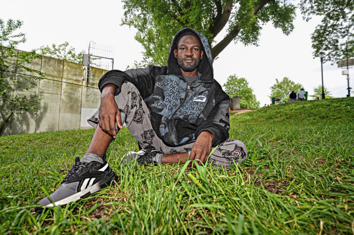 Migrant sitting on grass near shelter in New York