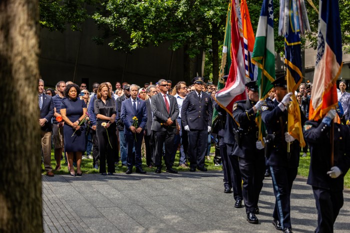 people attending a ceremony outside at the 9/11 Memorial