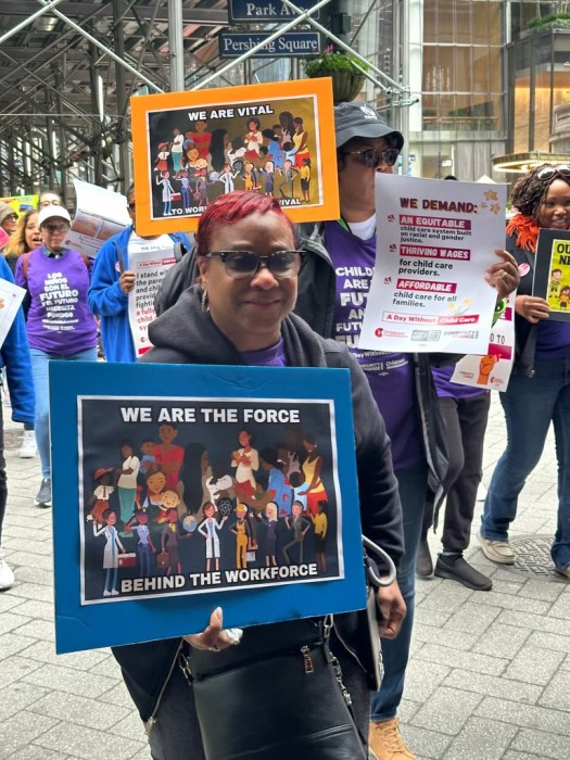 several people holding signs to support more funding for child care in NYC