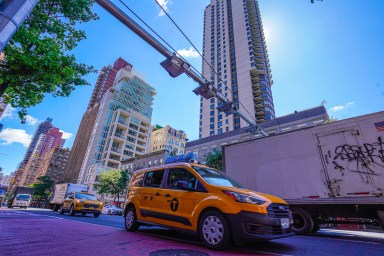 Cars go by congestion pricing gantry in Manhattan