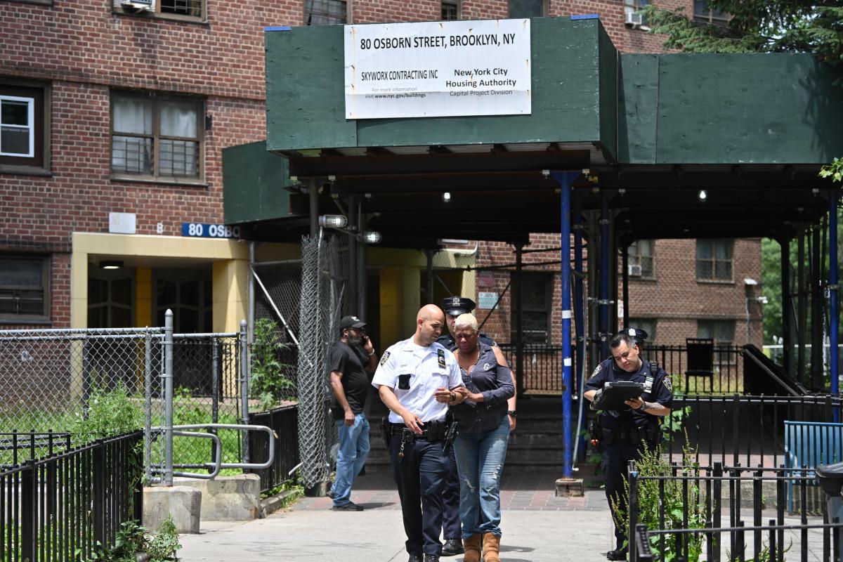 Police in Brooklyn escort resident from scene where teen was shot