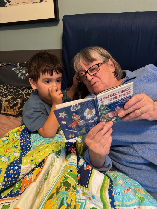 a woman, who is advocating for funding for NYC child-care programs reads to her grandson