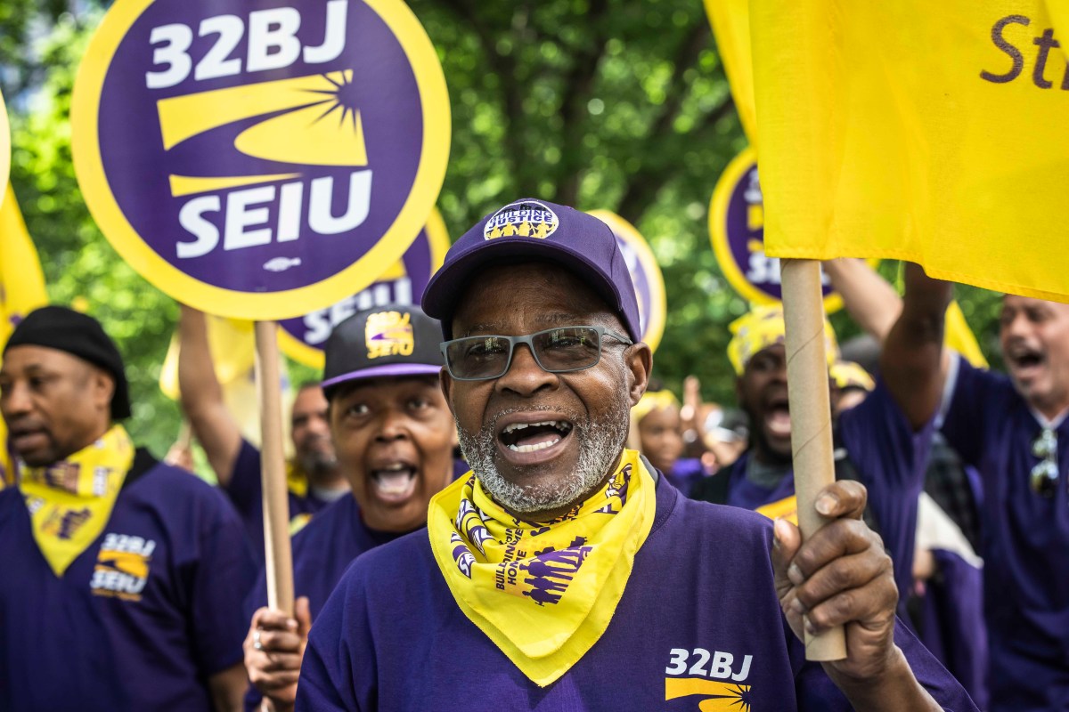 NYC public school cleaners and handyperson rallying outside holding signs that read 32BJ SEIU