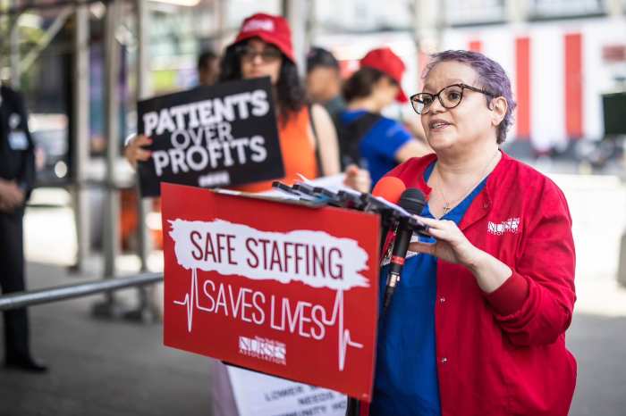 Nurses at embattled New York Eye and Ear Infirmary win new labor contract 3 people wearing red at a rally advocating for better work benefits for nurses at New York Eye and Ear Infirmary