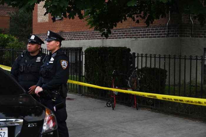 Senior in Brooklyn hit by stray bullet while sitting in her walker: cops 5 uniformed NYPD outside near police tape in Brooklyn
